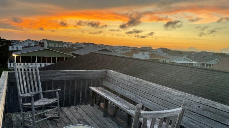 Two rocking chairs on the roof at sunset