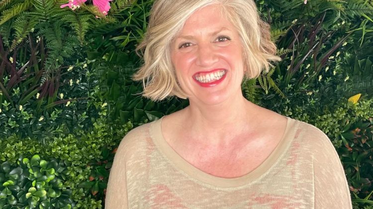 Emily Oehler in front of green plant background