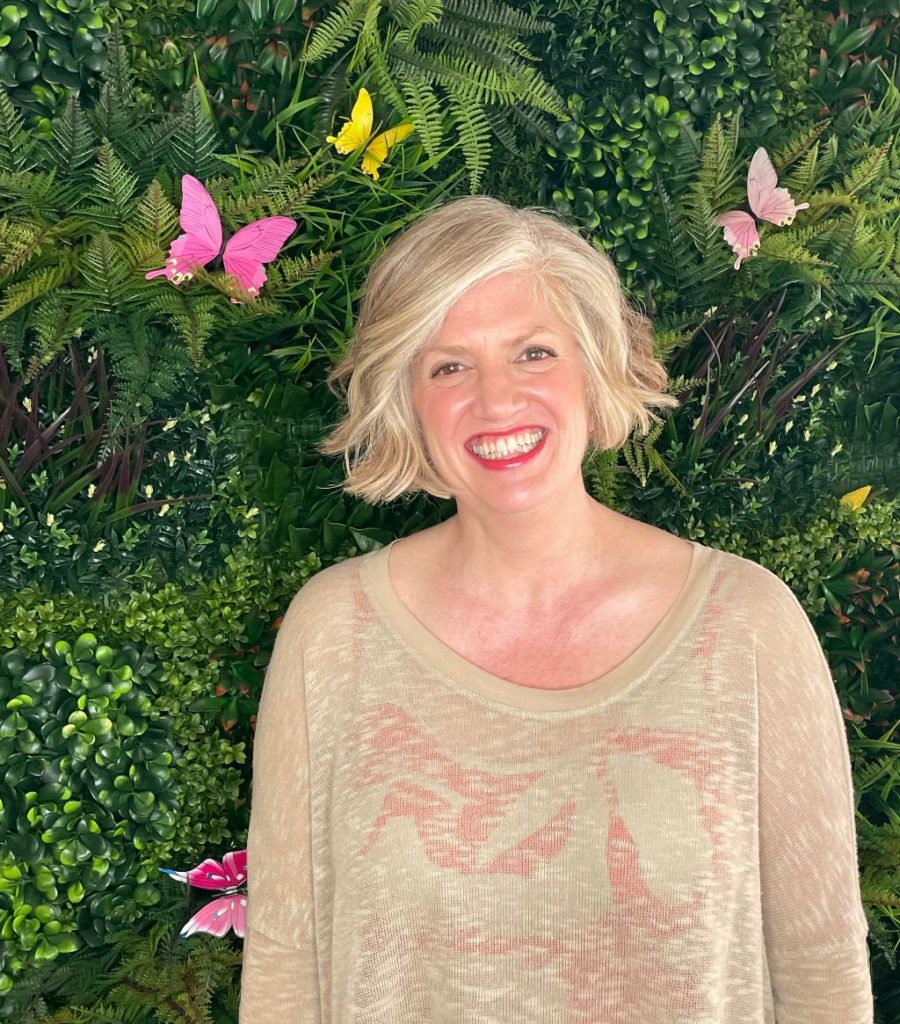 Emily Oehler in front of green plant background