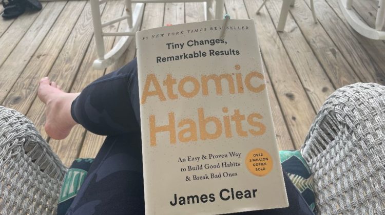 Book called Atomic Habits is on a person's lap