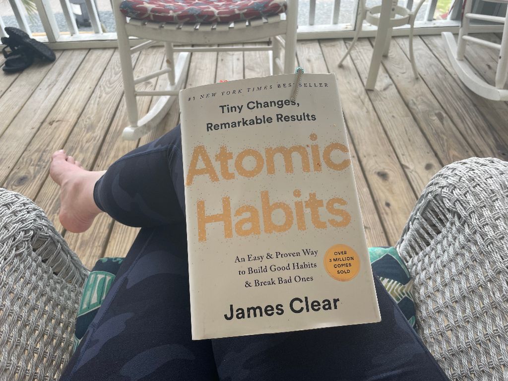 Book called Atomic Habits is on a person's lap