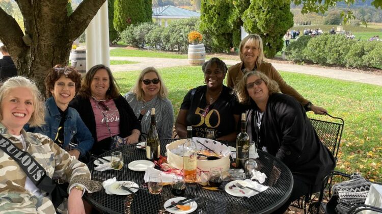 Emily with friends around a table outside