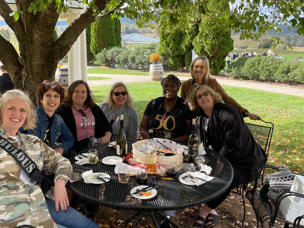 Emily with friends around a table outside