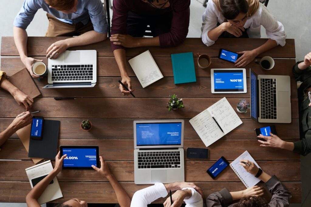 People meeting around a table with computers