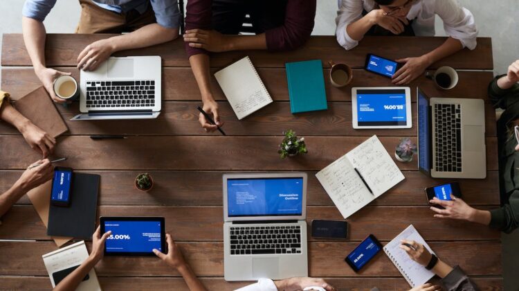 People meeting around a table with computers