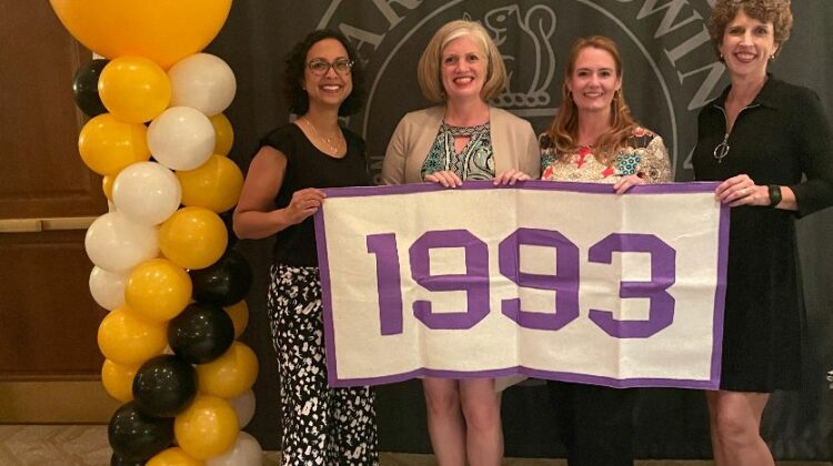 4 women hold banner with 1993 on it