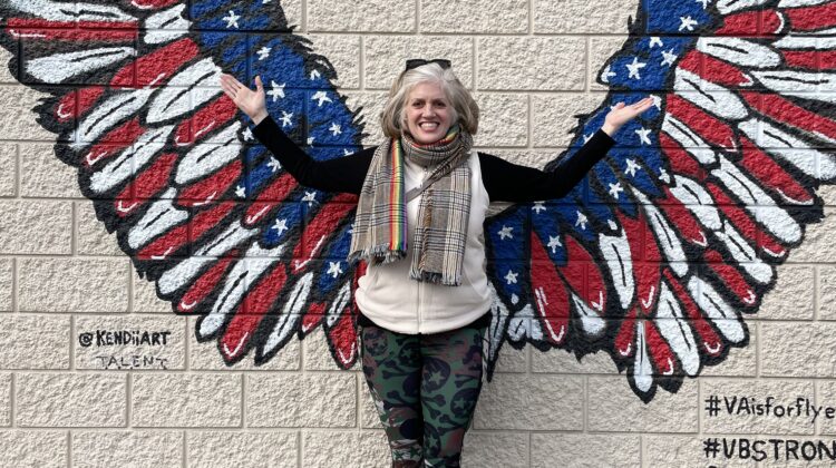 woman in front of wall where wings are painted