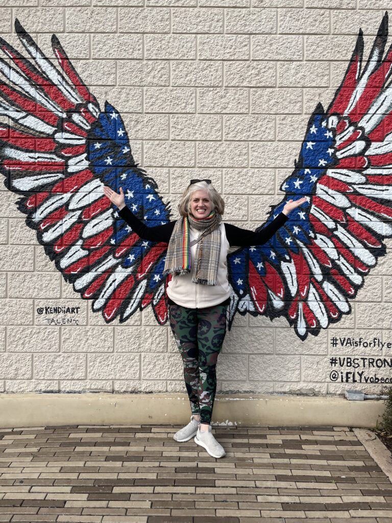 woman in front of wall where wings are painted