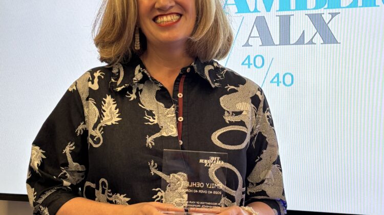 Emily Oehler holding "40 over 40" leadership award