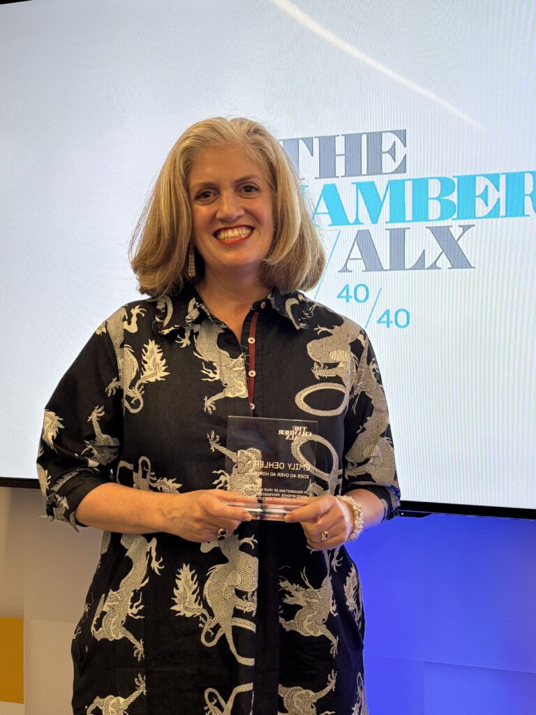 Emily Oehler holding "40 over 40" leadership award