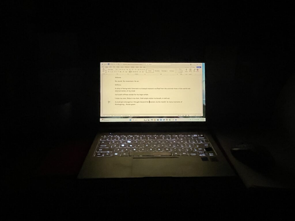 Computer glowing in a dark room
