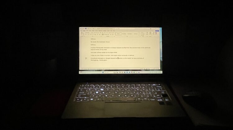Computer glowing in a dark room
