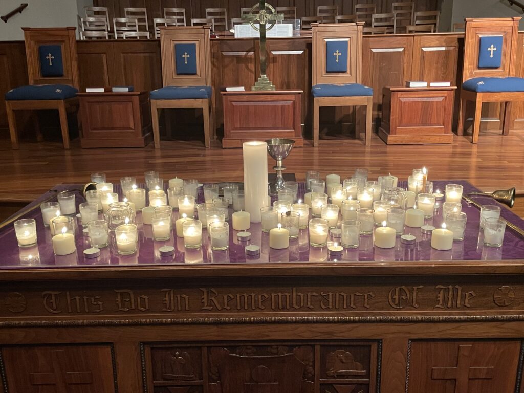 lit white candles on a wooden table