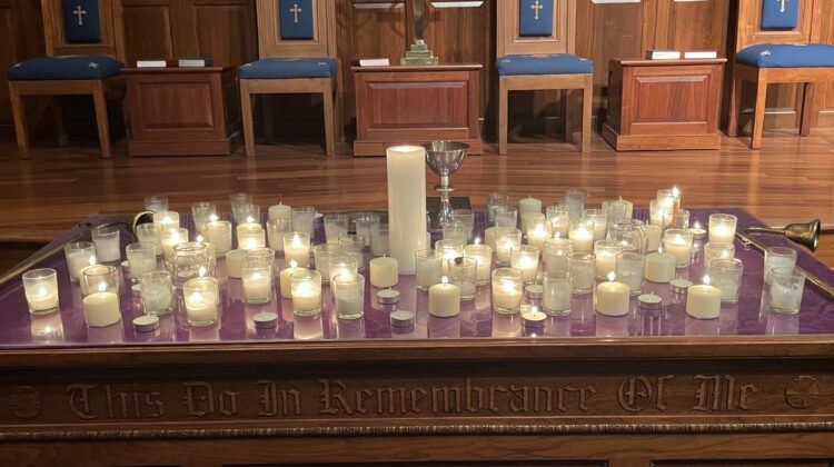 lit white candles on a wooden table