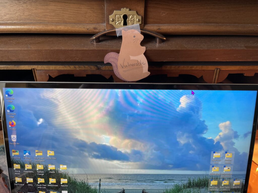 Computer with the word vulnerable taped above it